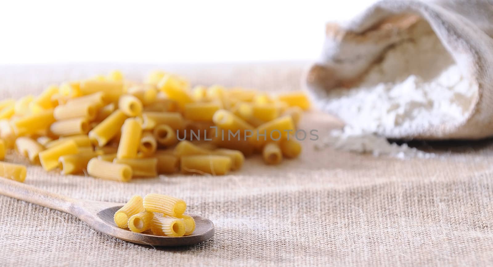 Macaroni in a spoon on the kitchen table.