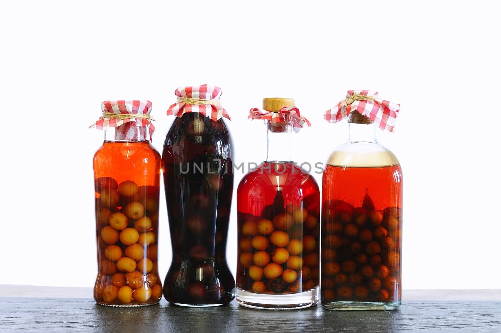 Bottles of cherry liqueur on white background.