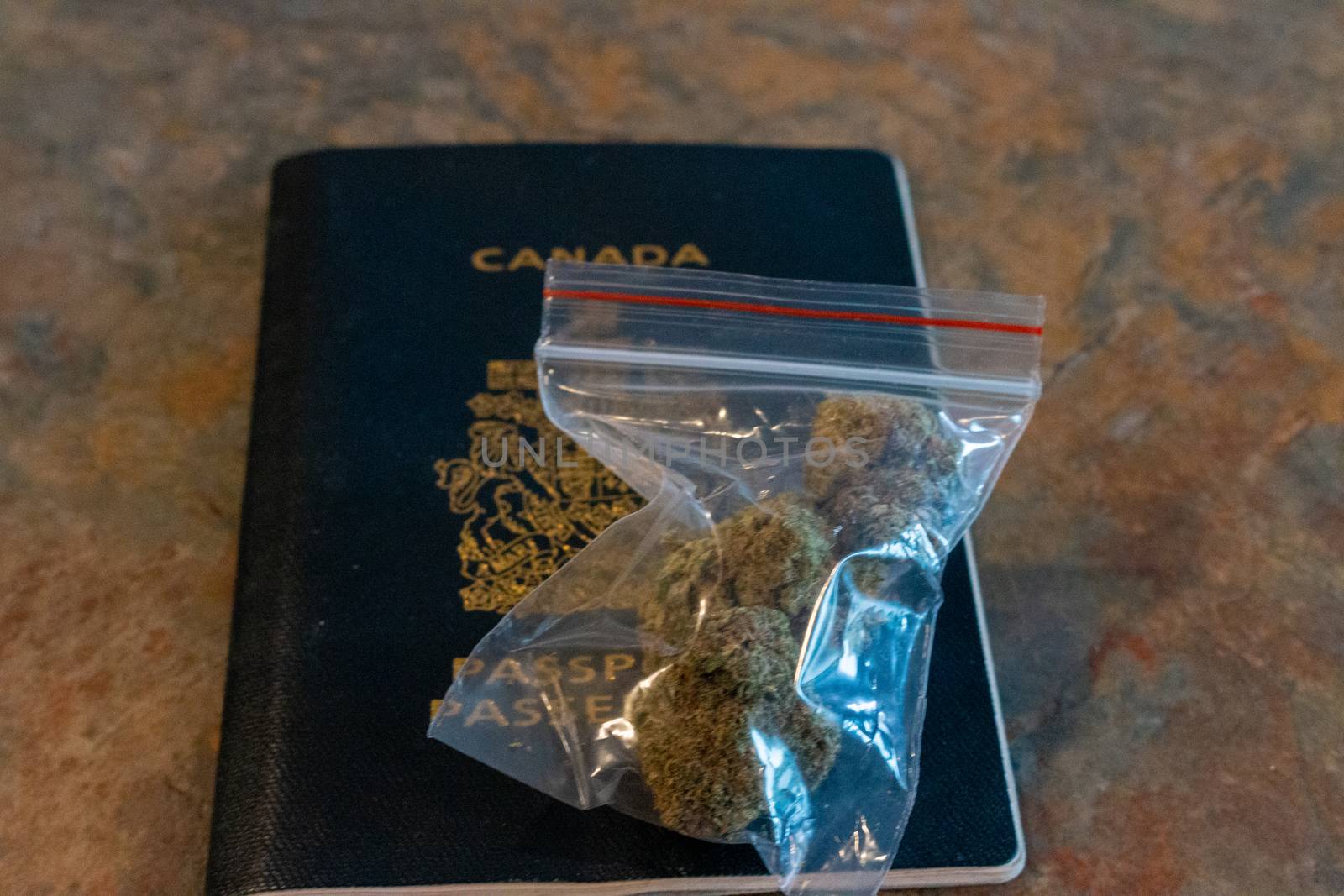 bag of marijuana on a canadian passport. theme of legal recreational cannabis usage. by mynewturtle1