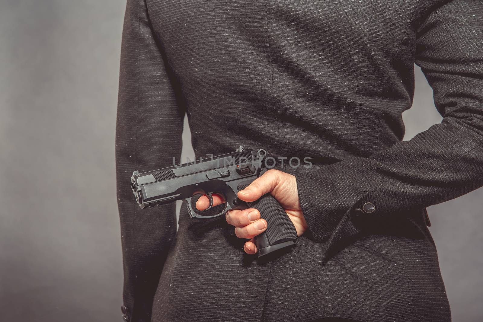 Portrait of woman with gun on blue background.