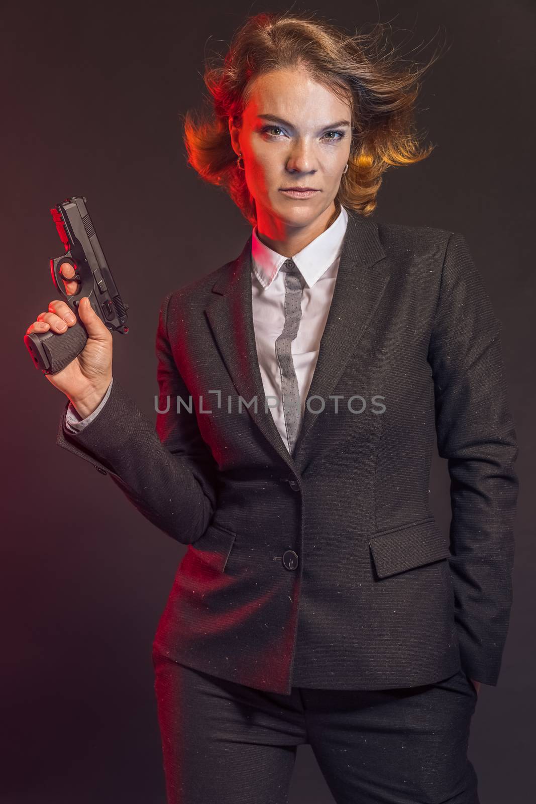 Portrait of woman with gun on brown background.