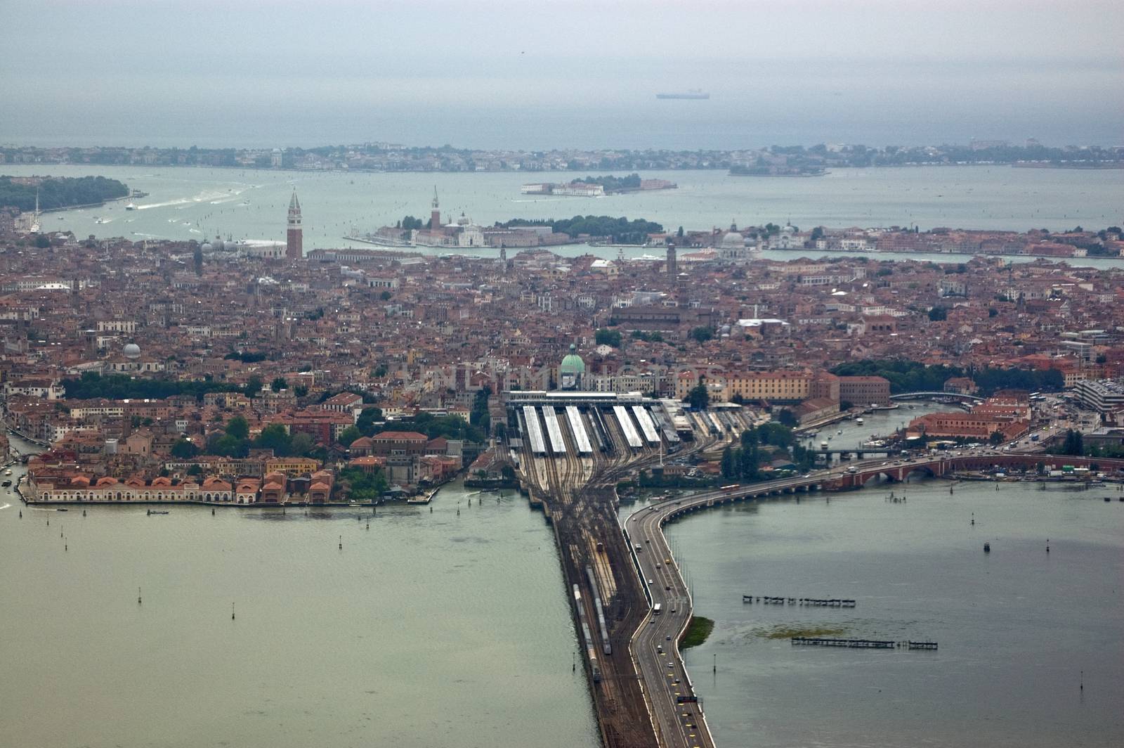 Venice, Italy as seen from the air. The road and rail link from Piazzale Roma and the railway station actoss the Ponte della Liberta to the mainland is in the foreground.