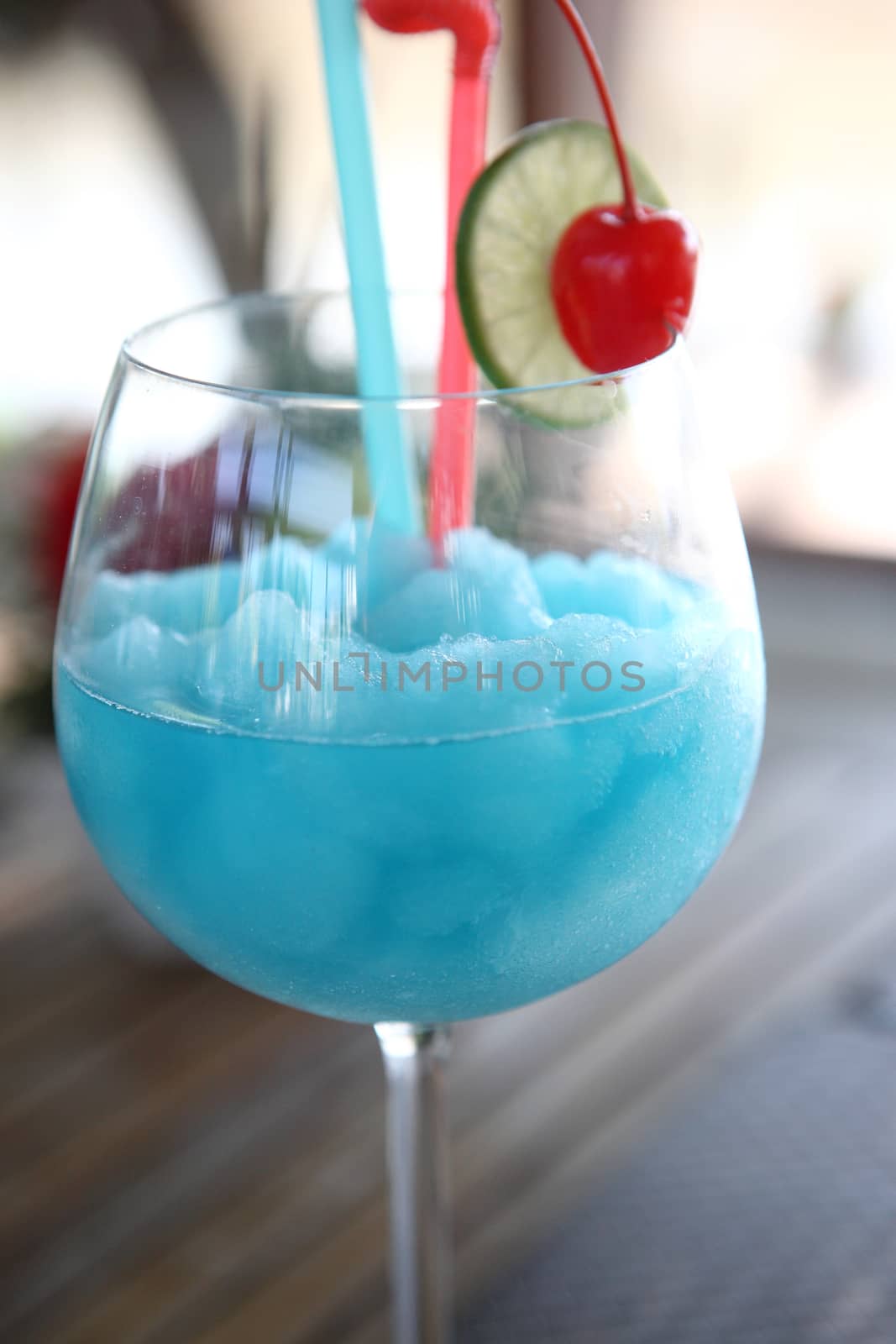 Blue cocktail with cherry and lime , kamikaze