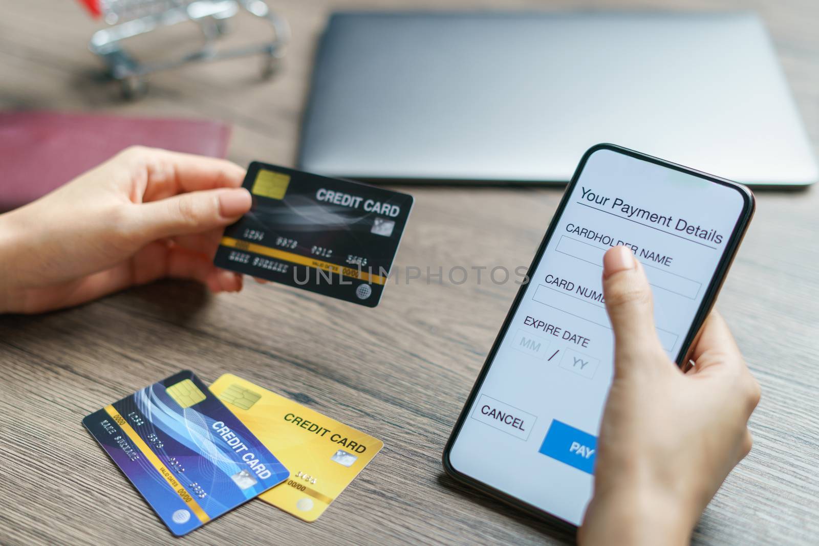 Mobile payments. hands using smartphone and credit card for online shopping. (Fake Screen)