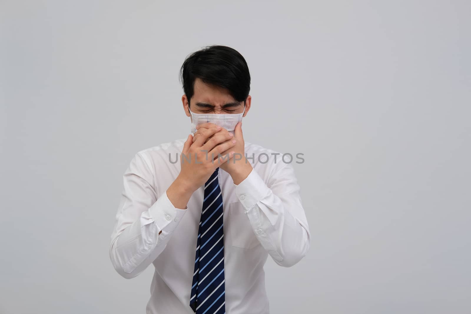 ill businessman man feeling sick, sneezing coughing wearing protective mask against cold flu virus bacteria infection pollution