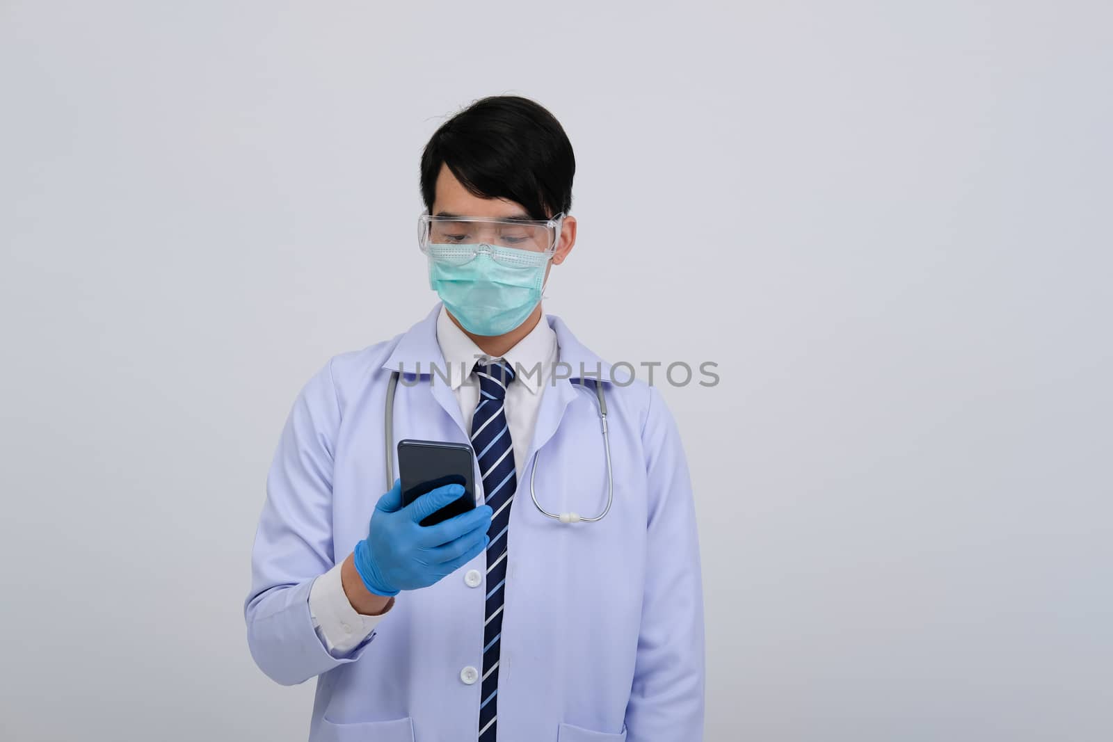 doctor physician practitioner wearing mask with smartphone & stethoscope on white background. medical professional medicine healthcare concept