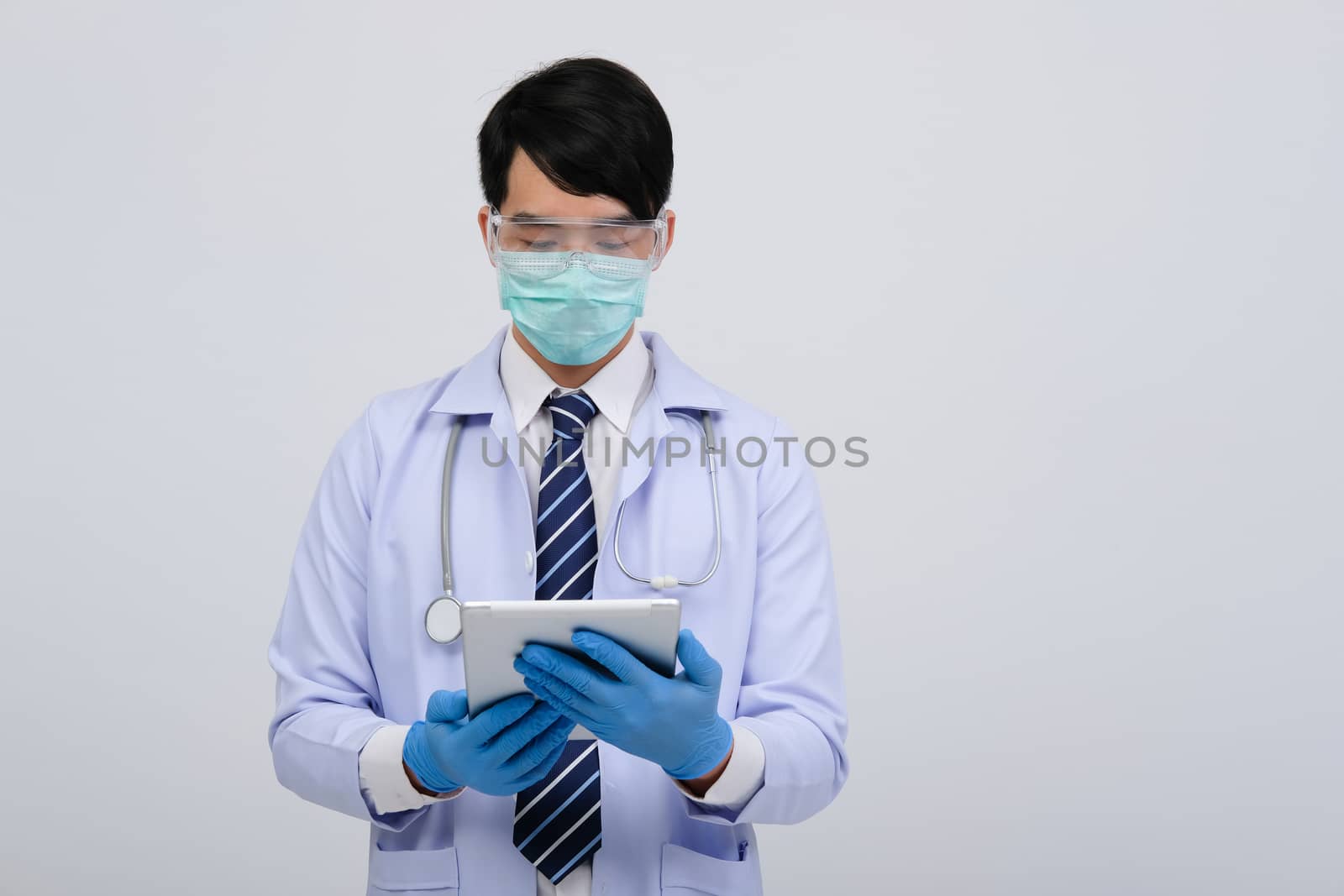 doctor physician practitioner wearing mask with tablet & stethoscope on white background. medical professional medicine healthcare concept