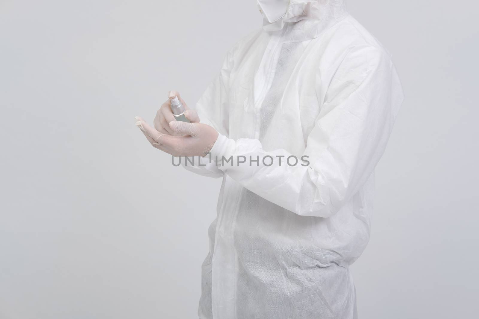 man doctor wearing biological protective uniform suit clothing, mask, gloves with hand alcohol sanitizer dispenser for sanitizing virus bacteria