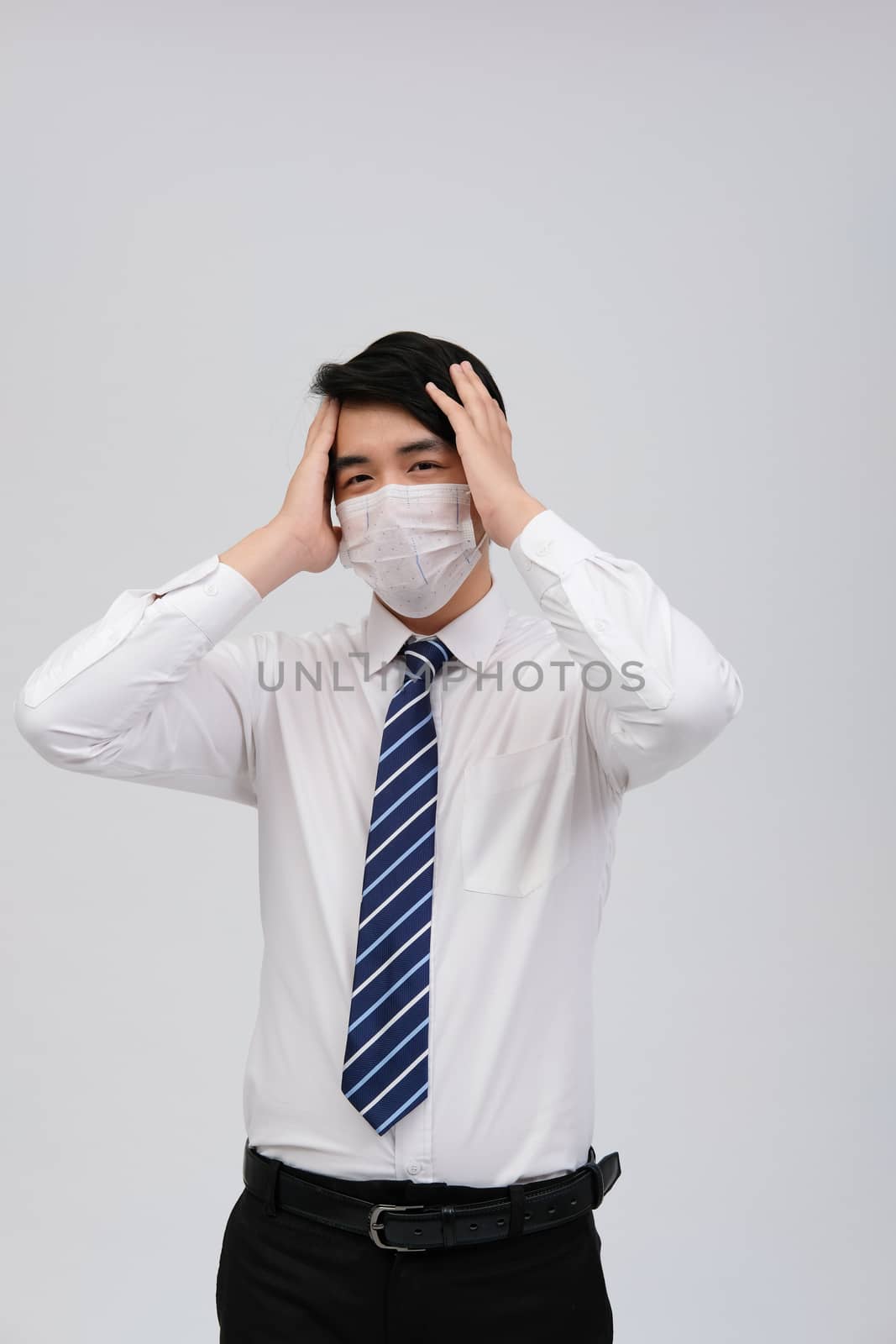 ill businessman man feeling sick, headache wearing protective mask against cold flu virus bacteria infection pollution