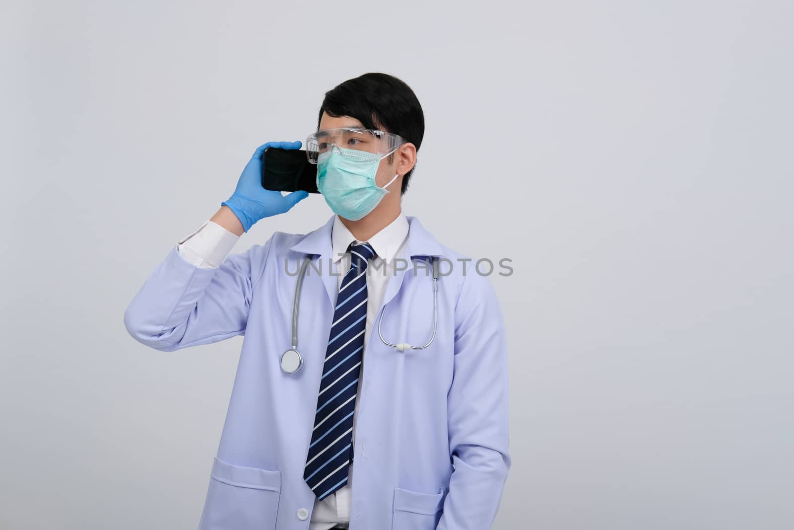 doctor physician practitioner wearing mask with smartphone & stethoscope on white background. medical professional medicine healthcare concept