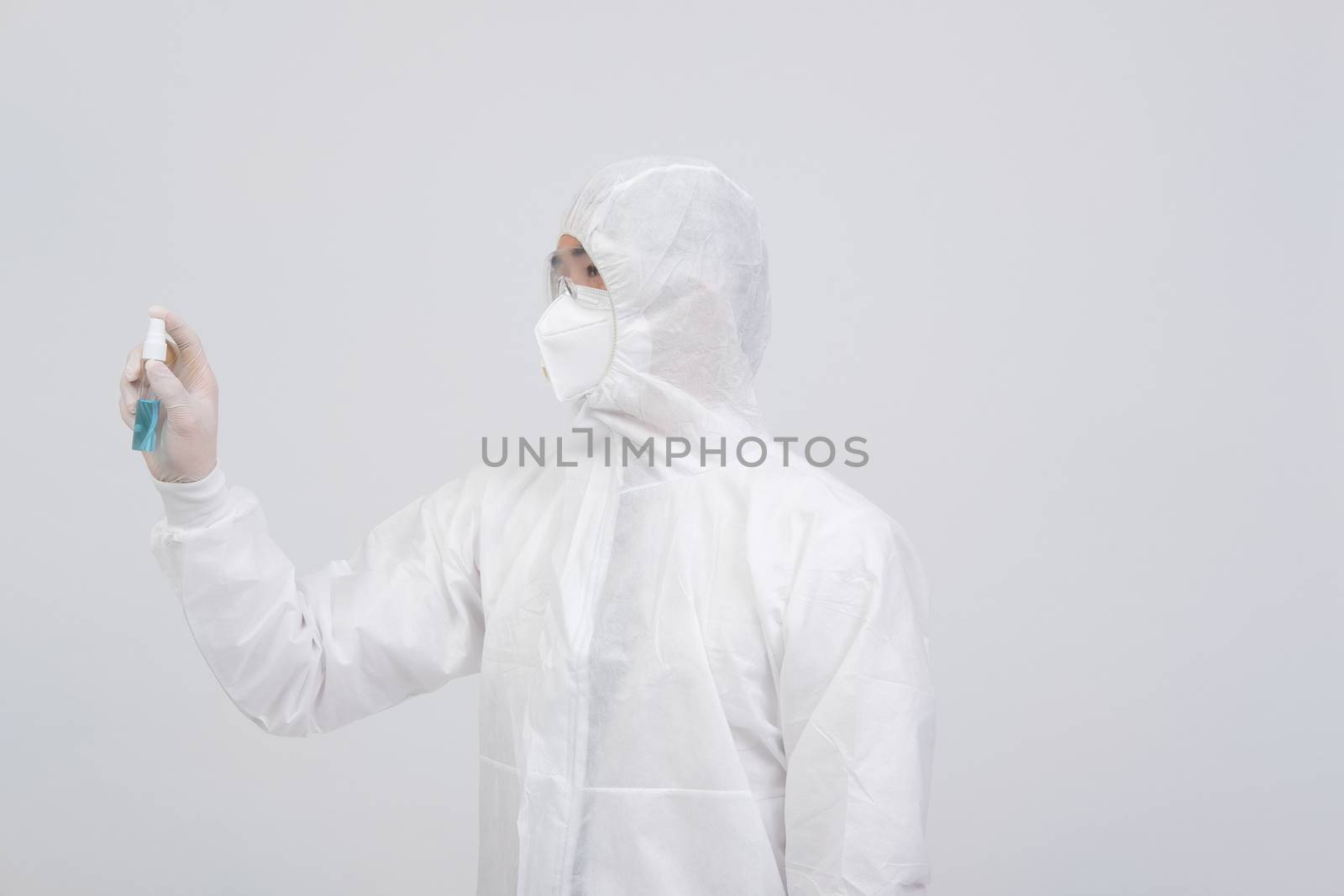 man doctor wearing biological protective uniform suit clothing, mask, gloves with hand alcohol sanitizer dispenser for sanitizing virus bacteria