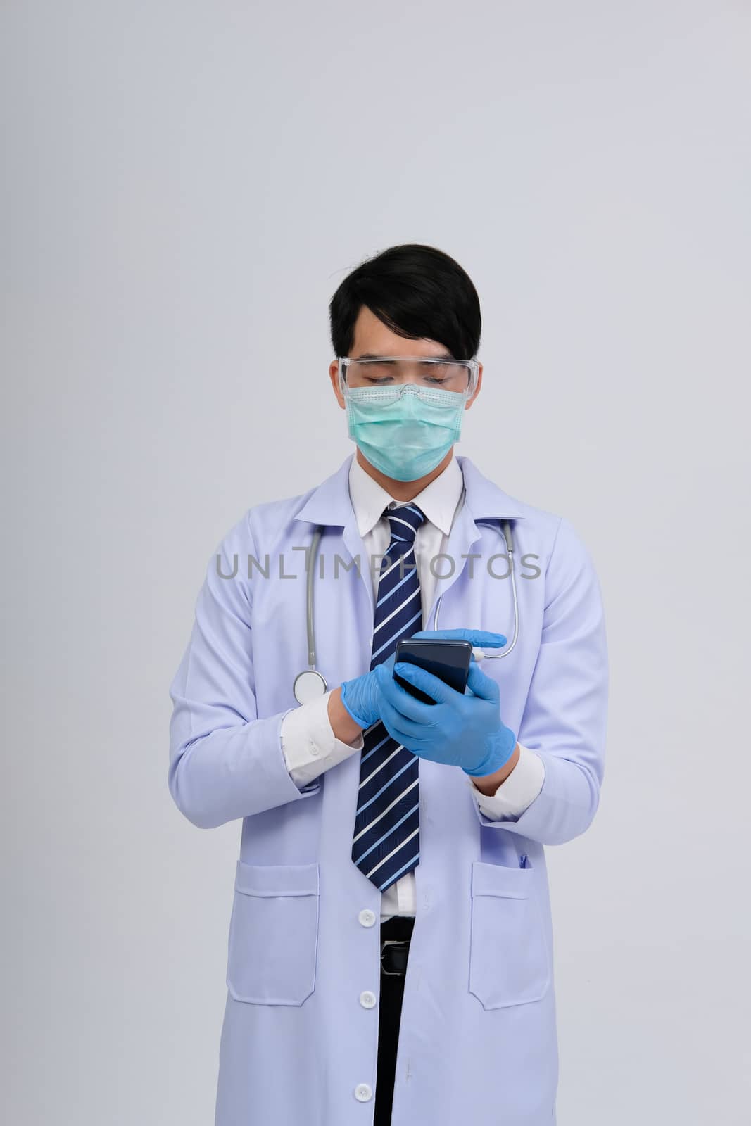 doctor physician practitioner wearing mask with smartphone & stethoscope on white background. medical professional medicine healthcare concept