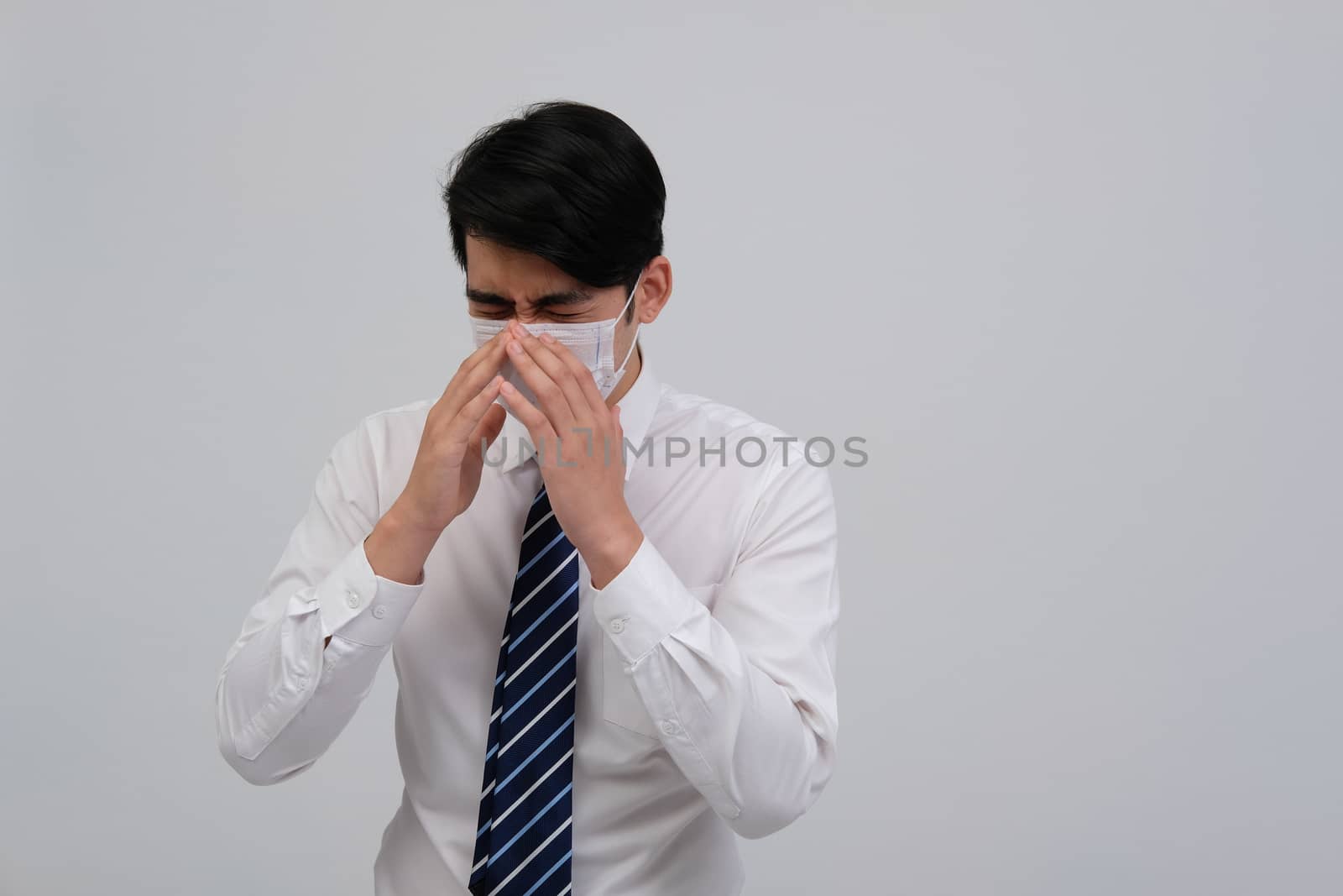 ill businessman man feeling sick, sneezing coughing wearing protective mask against cold flu virus bacteria infection pollution