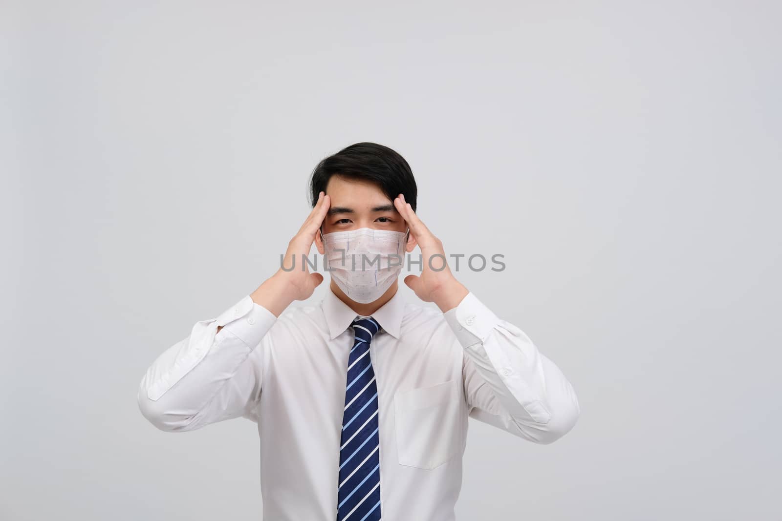 ill businessman man feeling sick, headache wearing protective mask against cold flu virus bacteria infection pollution