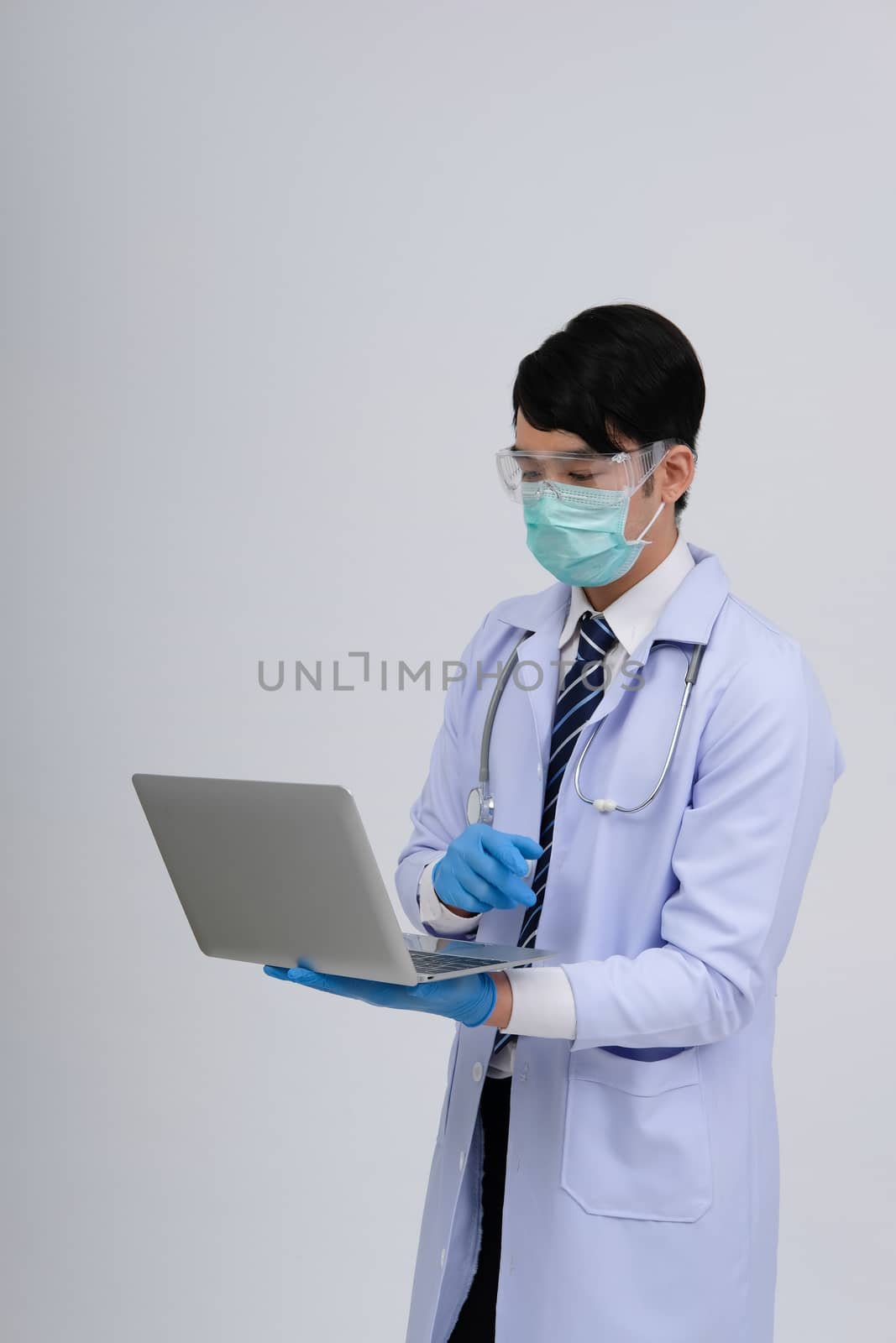 doctor physician practitioner wearing mask with computer & stethoscope on white background. medical professional medicine healthcare concept