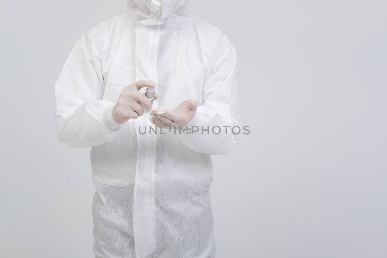 man doctor wearing biological protective uniform suit clothing, mask, gloves with hand alcohol sanitizer dispenser for sanitizing virus bacteria