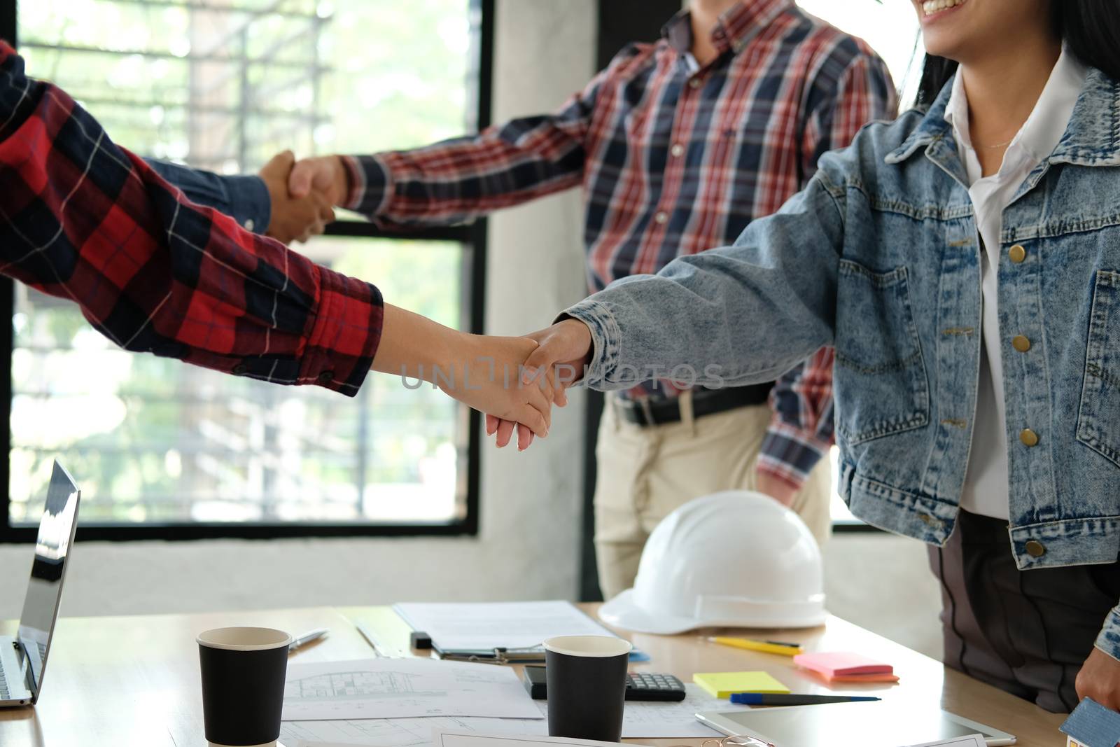 engineer team handshaking. architect shaking hands for successful deal in building construction project. teamwork cooperation concept