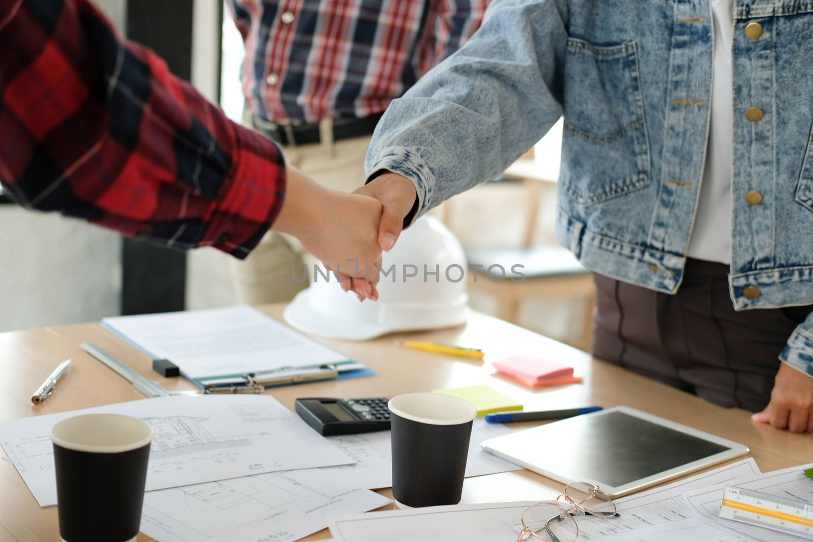 engineer team handshaking. architect shaking hands for successful deal in building construction project. teamwork cooperation concept