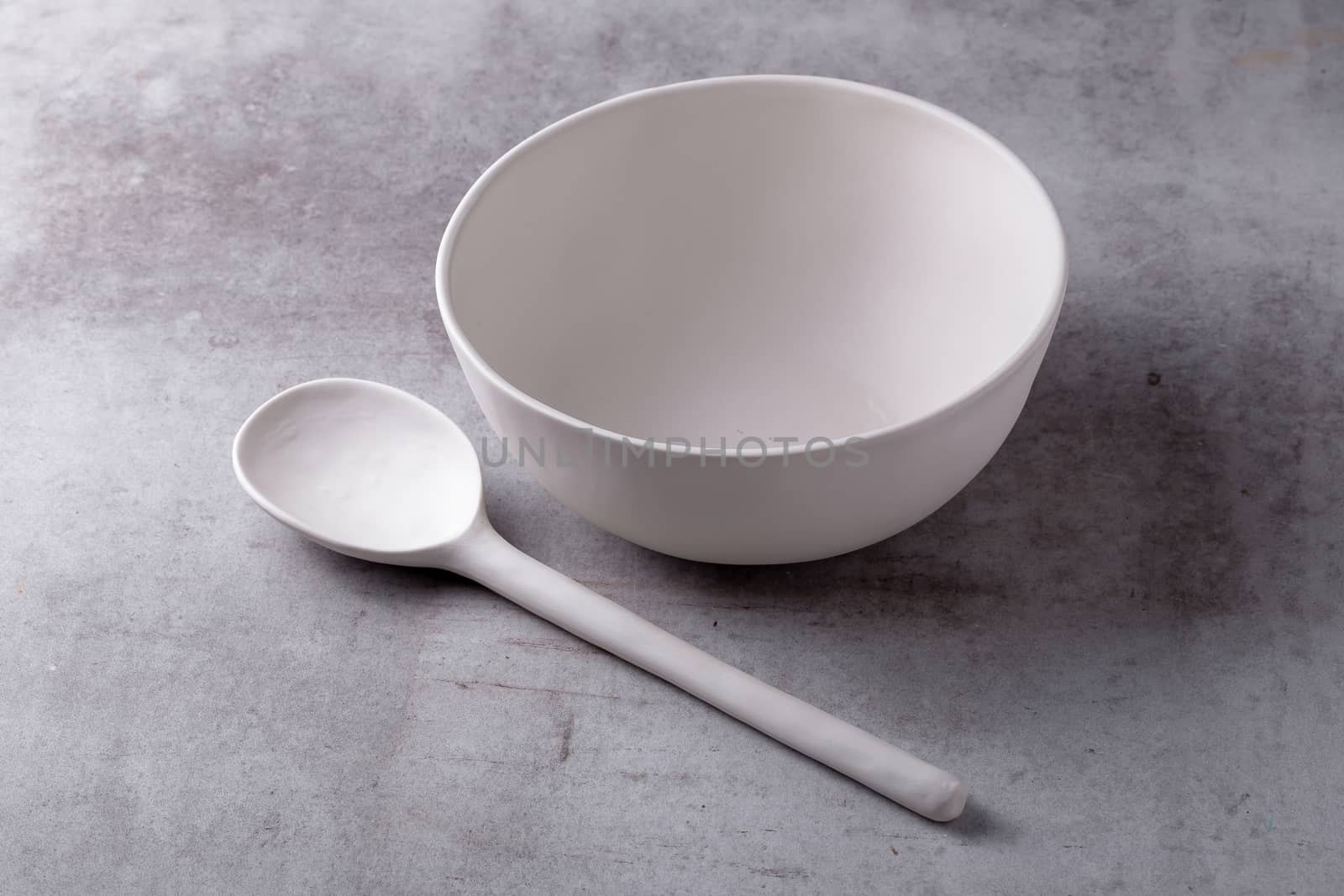 Empty blank white ceramic Bowl and spoon on Cement Board by kaiskynet