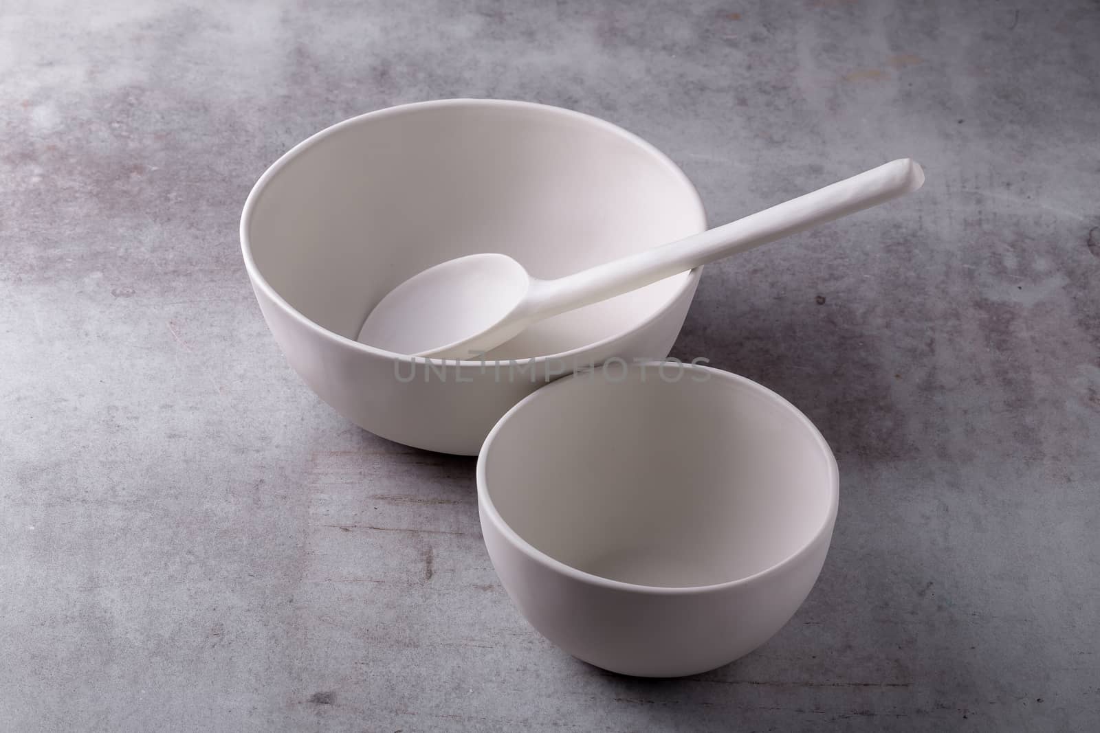 Empty blank white ceramic Bowl and spoon on Cement Board by kaiskynet