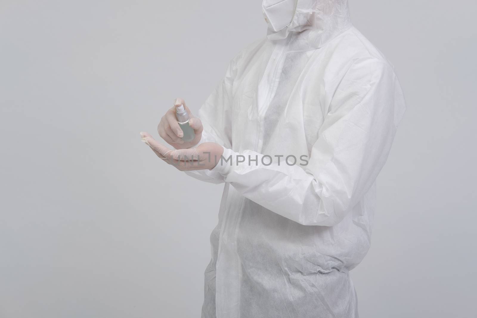 man doctor wearing biological protective uniform suit clothing, mask, gloves with hand alcohol sanitizer dispenser for sanitizing virus bacteria