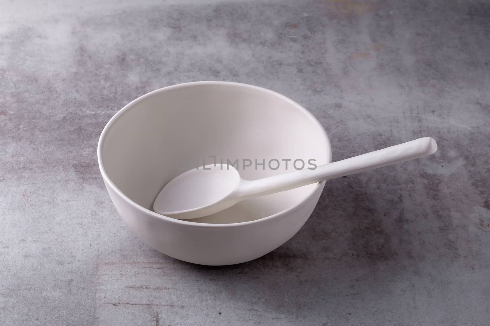 Empty blank white ceramic Bowl and spoon on Cement Board.