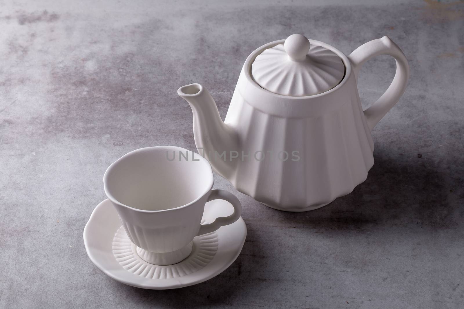 Teapot creamer, Cup and saucer on Cement Board.