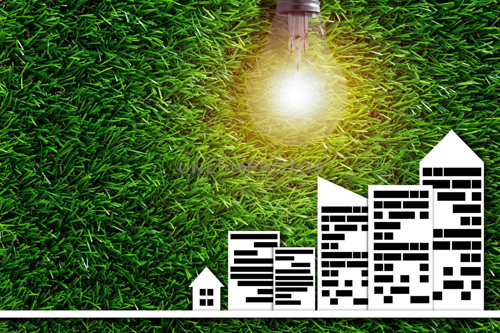 Ecology concept, save energy, paper city and light bulb on green grass