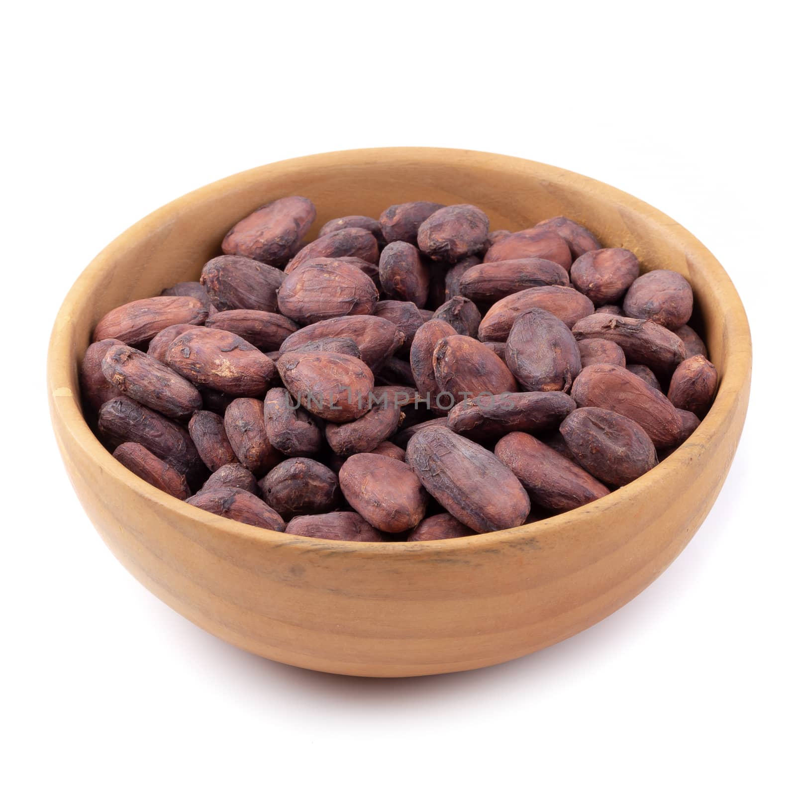 Cocoa fruit in a wooden bowl, raw cacao beans isolated on a white background.