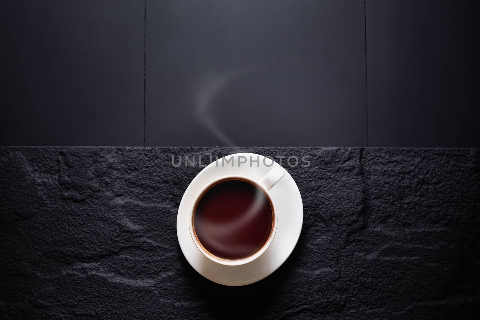 Hot chocolate and Cocoa pod cut exposing cocoa seeds on dark table, top view with copy space.