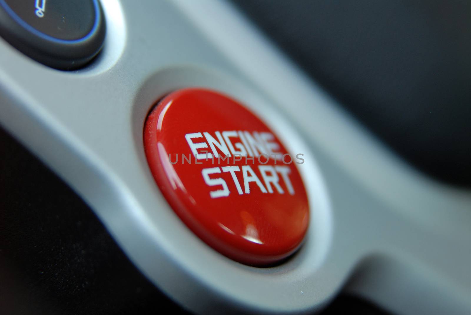 Start stop engine button on a modern sports car steering wheel by aselsa
