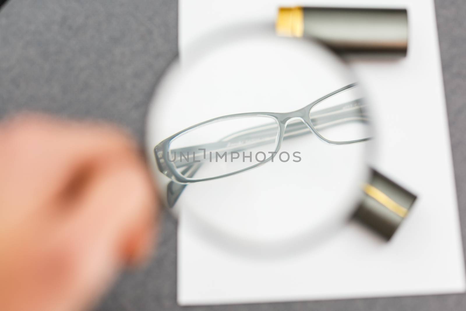 magnifier and glasses on a sheet of paper for business behind blind