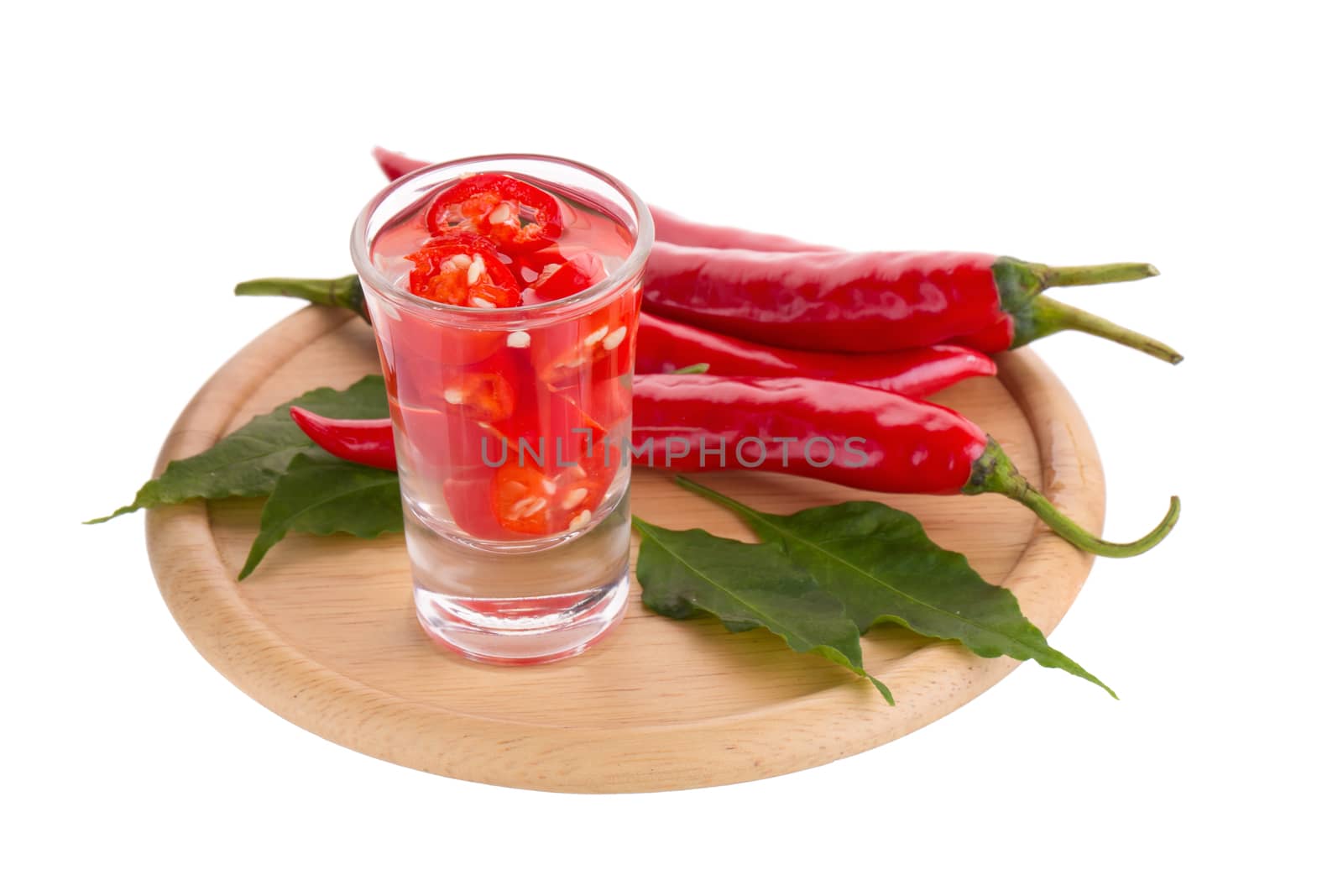 Slices of preserved red hot pepper in glass isolated on a white background.