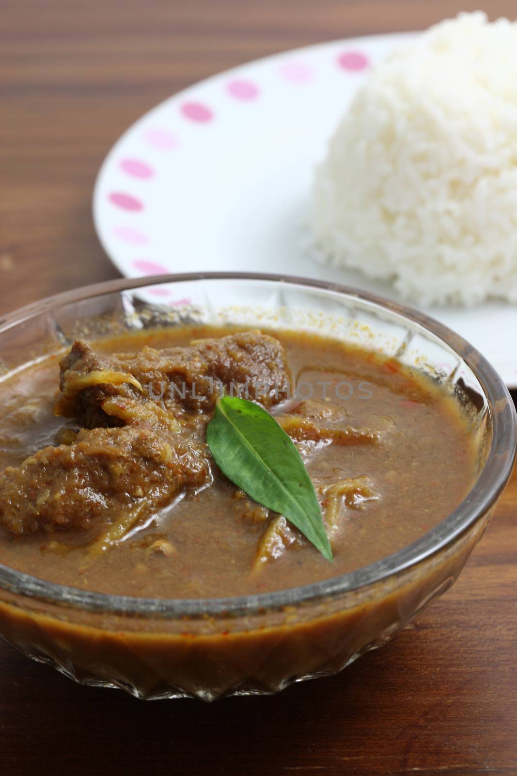 Thai food pork curry with rice in wood background