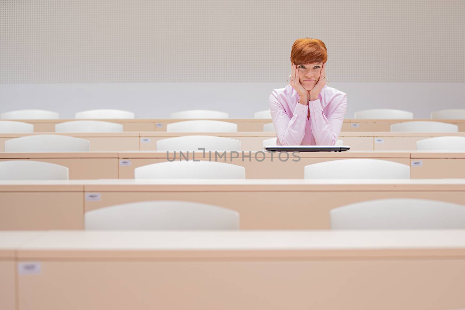 student in high school auditorium at school with white laptop by Edophoto