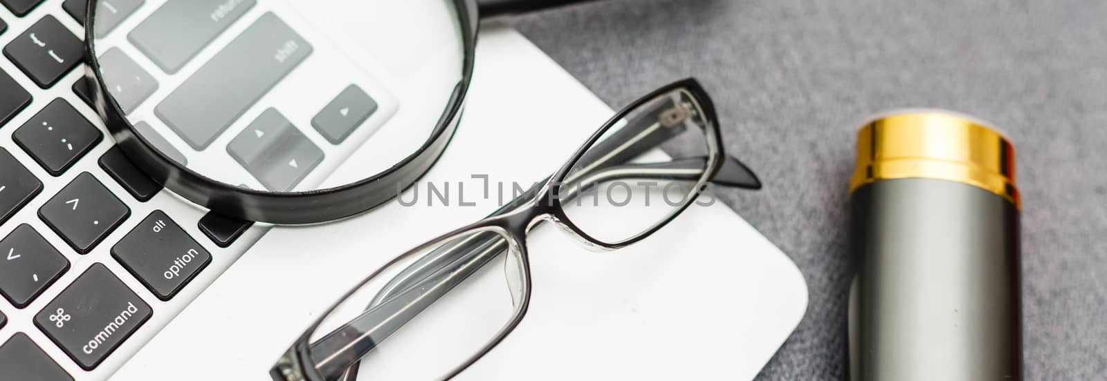 Business summary reports and a magnifying glass with glasses on table office. Concept of Data Analysis, Investment Planning, Business Analytics. by Andelov13