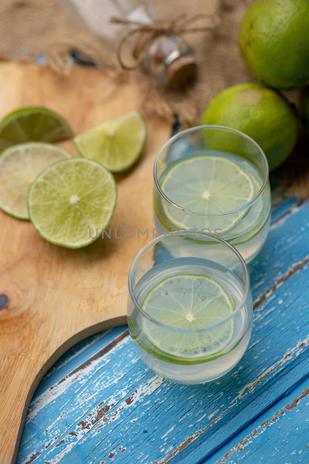 Lime juice and lemon on a blue wooden table by kaiskynet