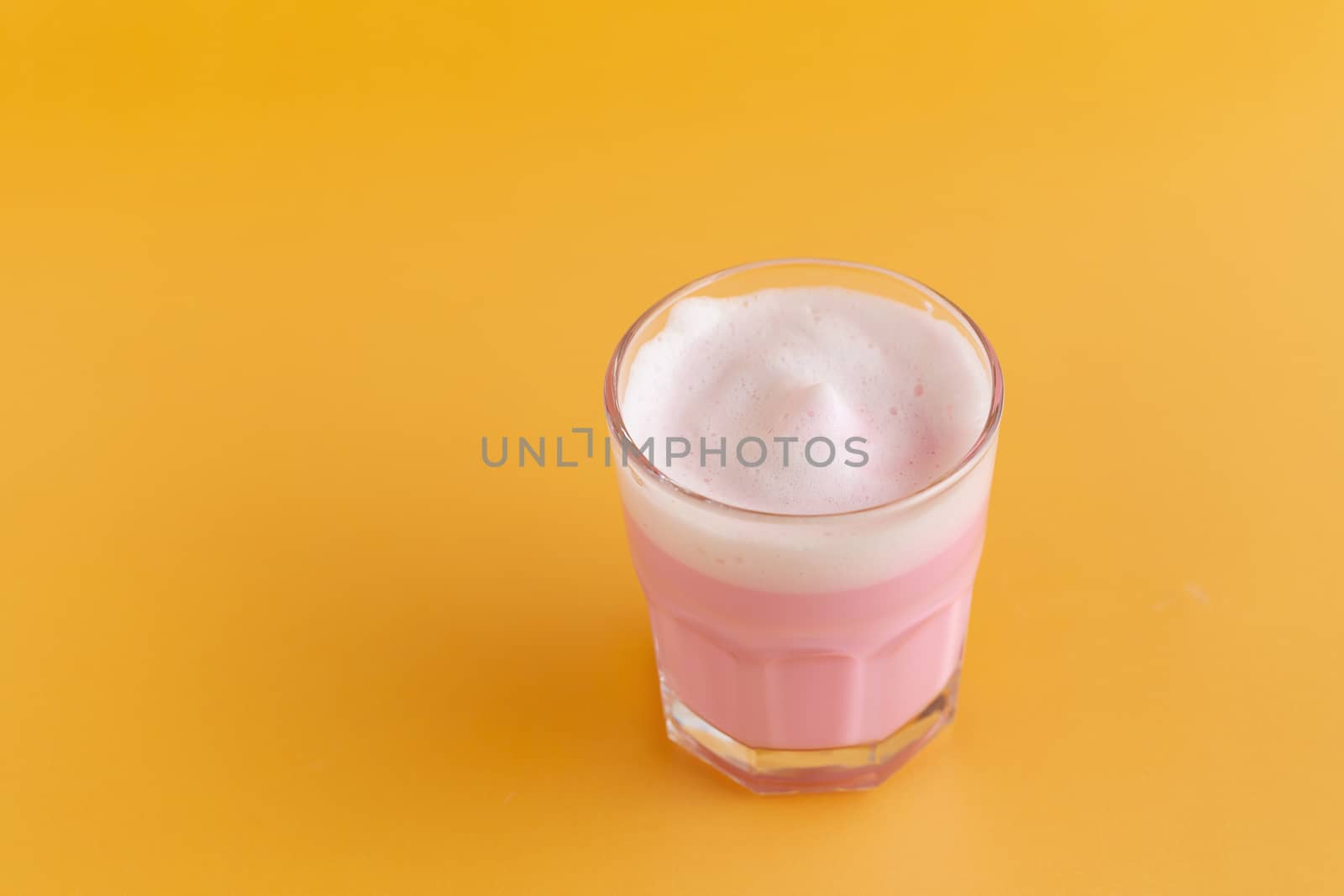 Strawberry milk shake from the glass on pink background.