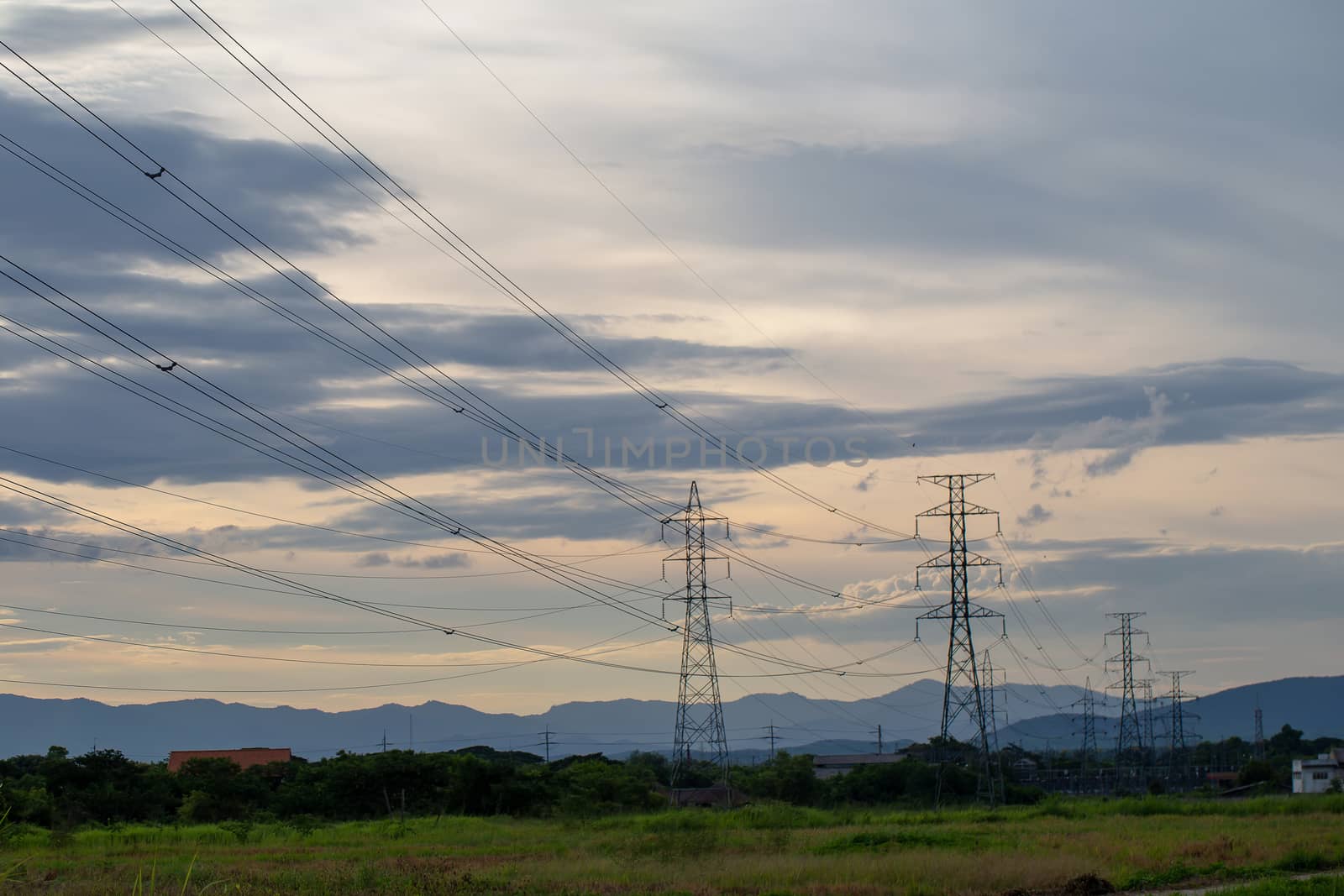 Colorful dramatic sky with Silhouette of high voltage pole and sunset.