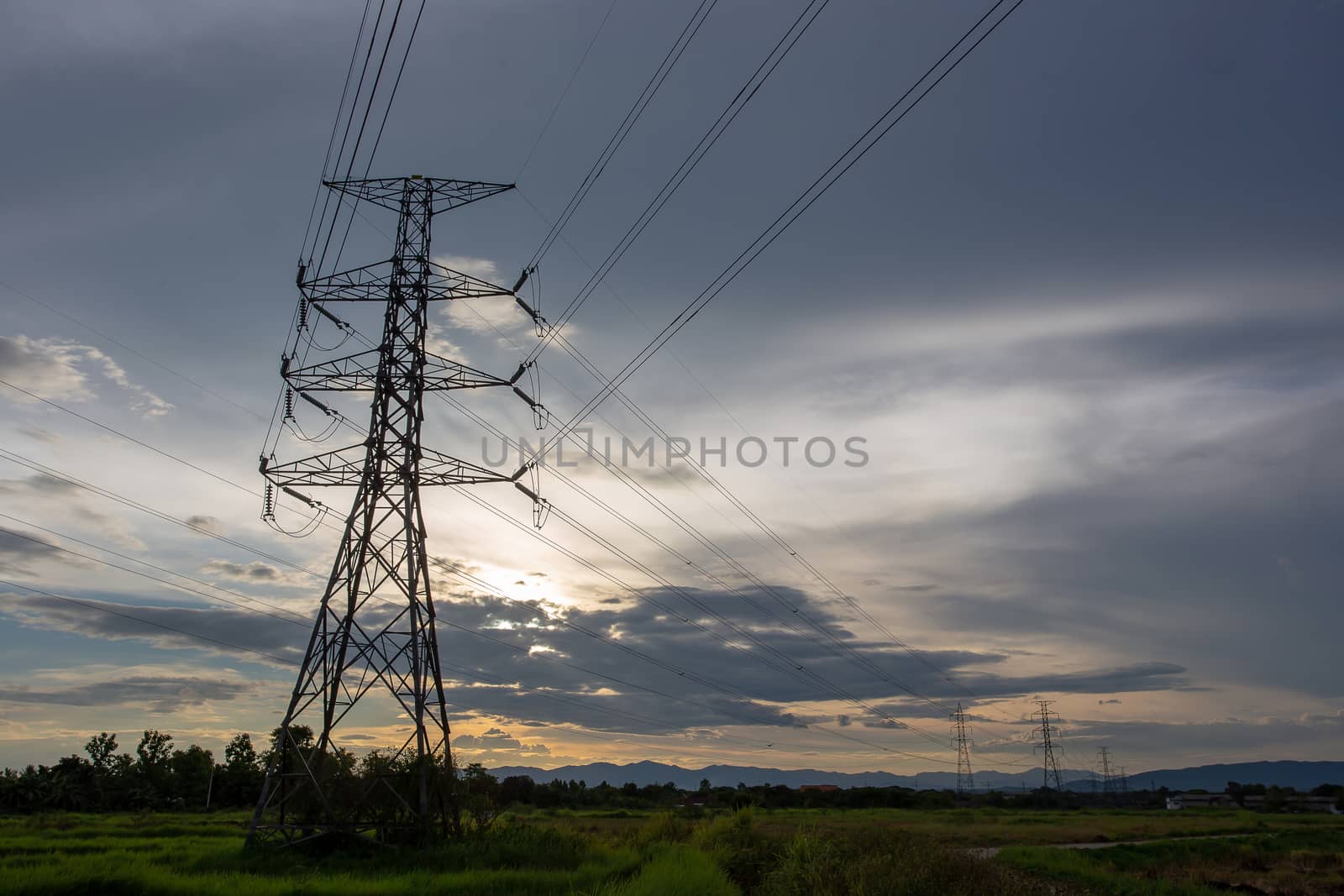 Colorful dramatic sky with Silhouette of high voltage pole and sunset.