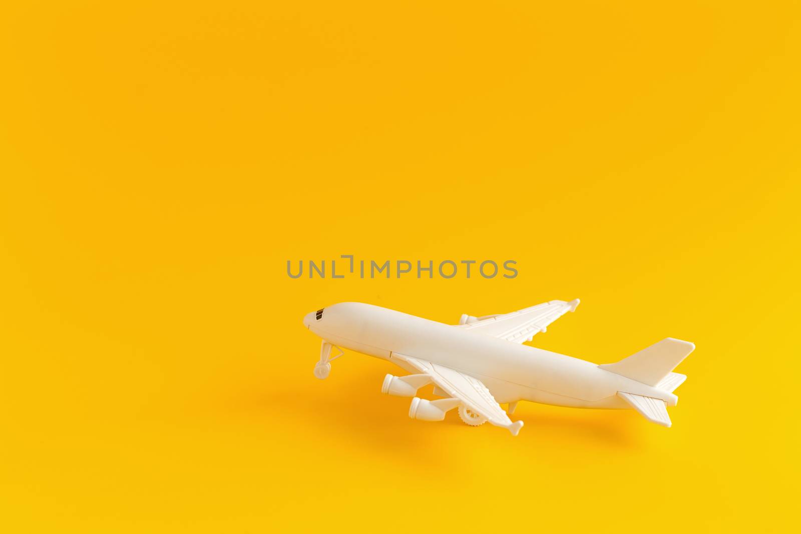 Plastic toy airplane on a yellow Background.