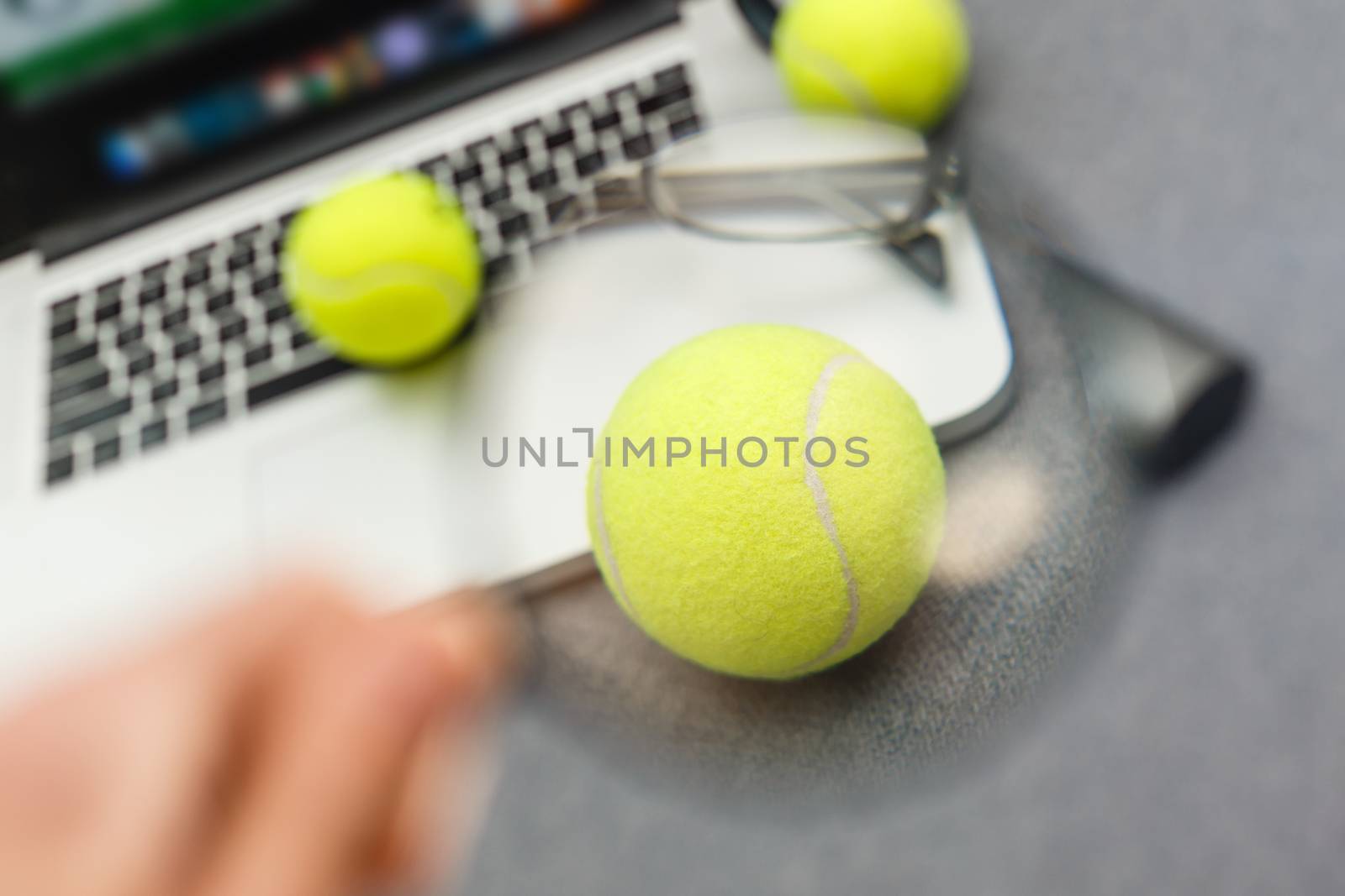 Top view of laptop, Sports Equipment, Tennis ball, Shuttlecock, glasses aon the Sports administration gray table.Business concept.