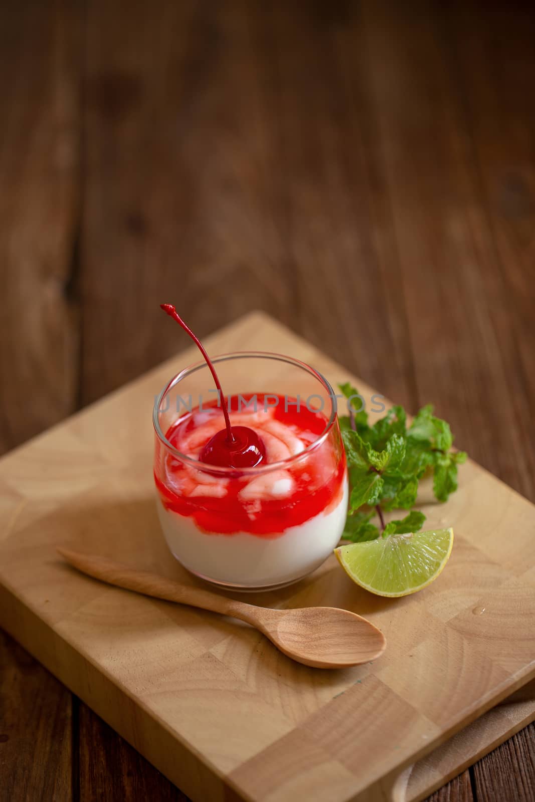 Glass of Cherry yogurt on a brown wood table by kaiskynet