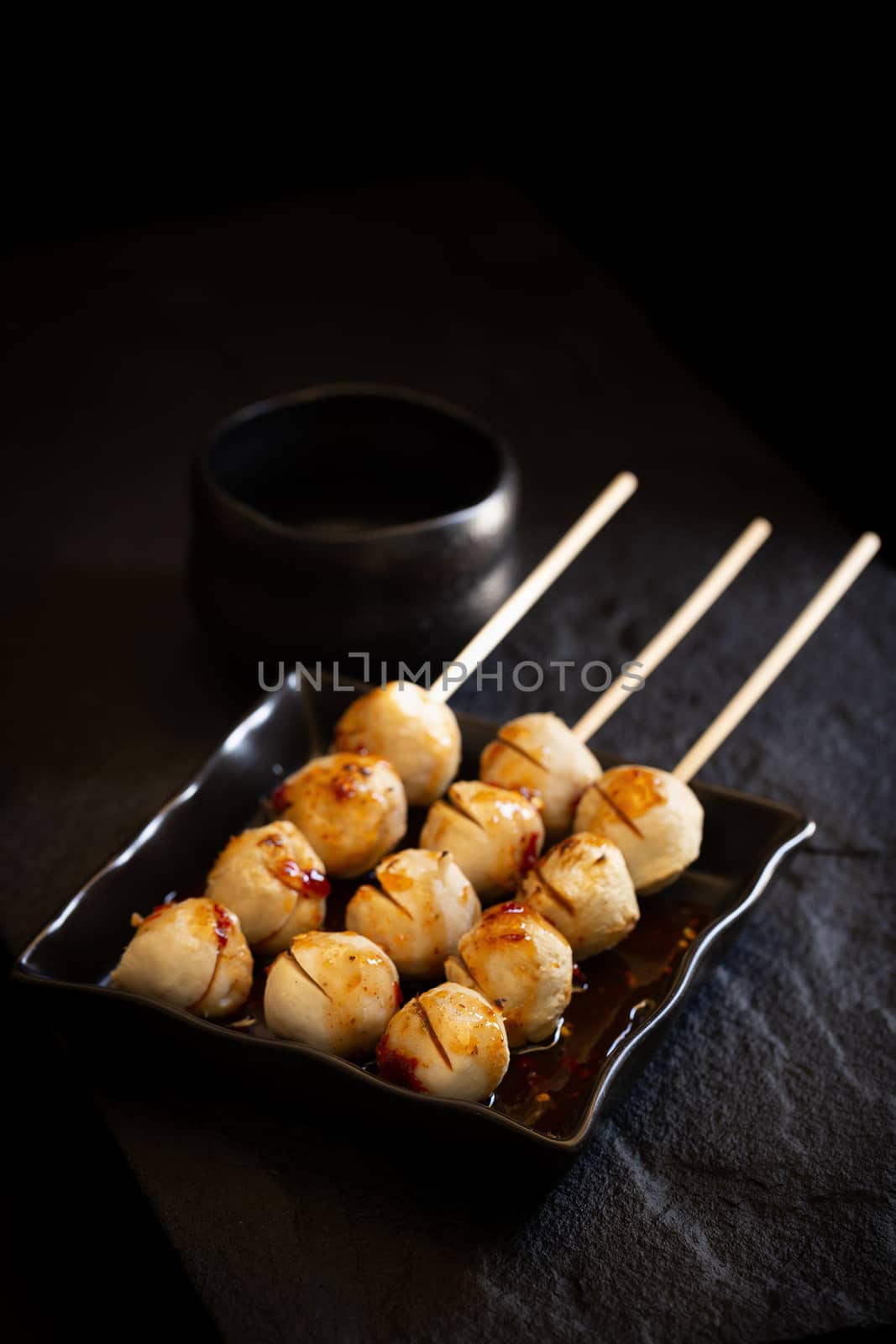 Roasted pork ball pour with sweet spicy sauce on dark background by kaiskynet