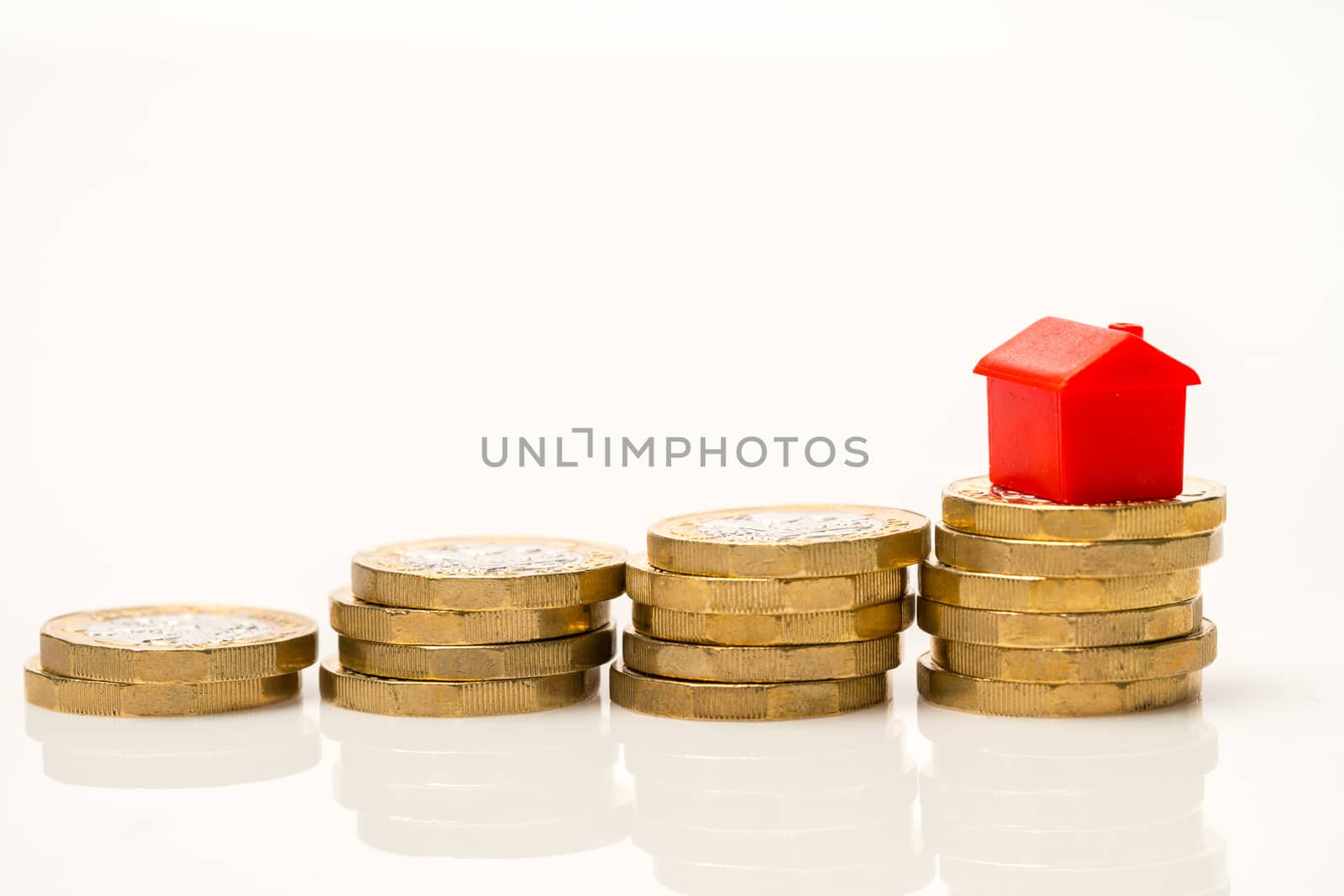 Housing estate concept with coins in studio by Alicephoto