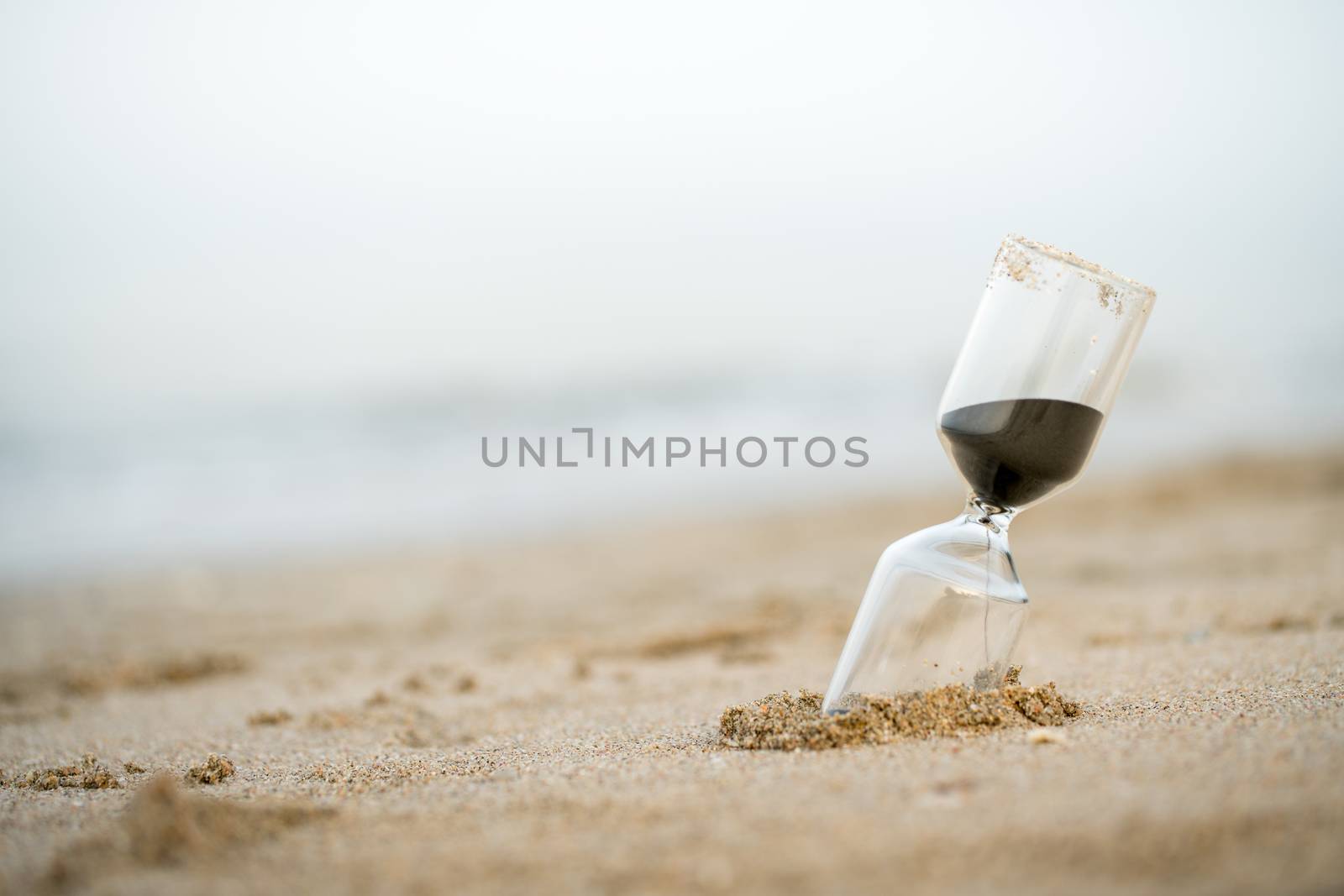 Sand clock on the beach, business time management concept by Alicephoto