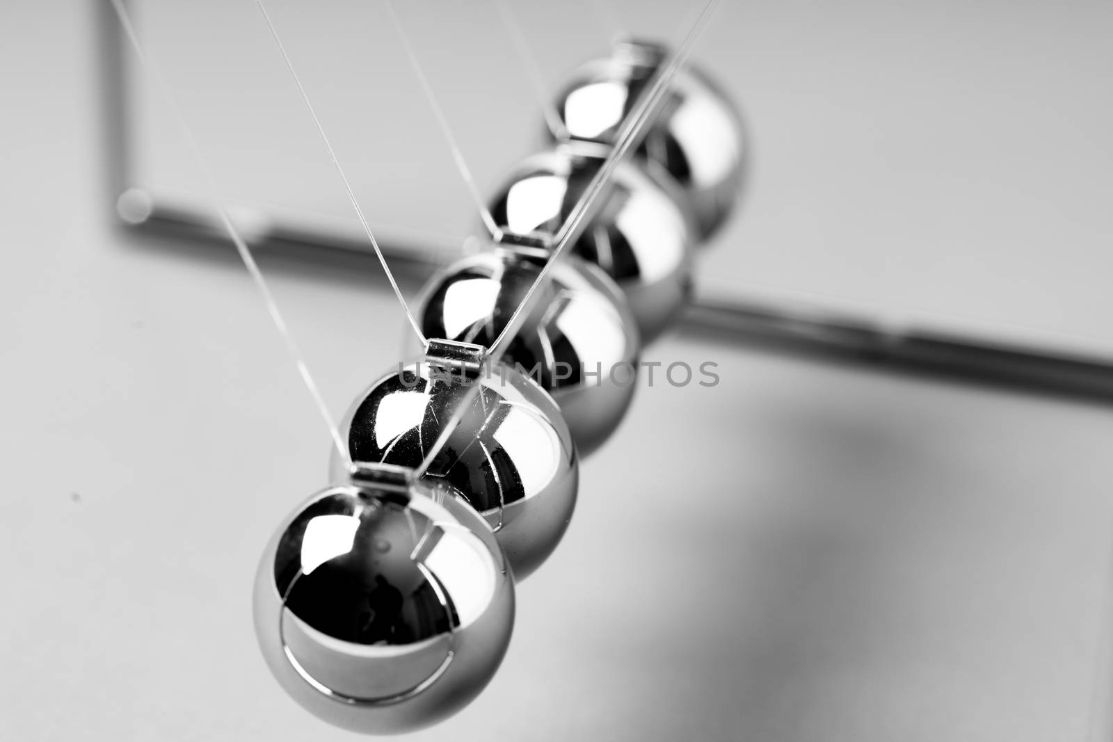 Newtons Cradle balancing balls, business concept in studio by Alicephoto