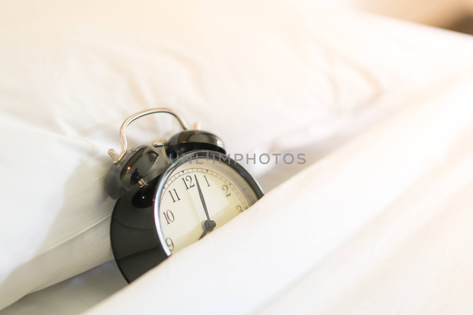 Metal Alarm clock on white bed 8 am. by Alicephoto