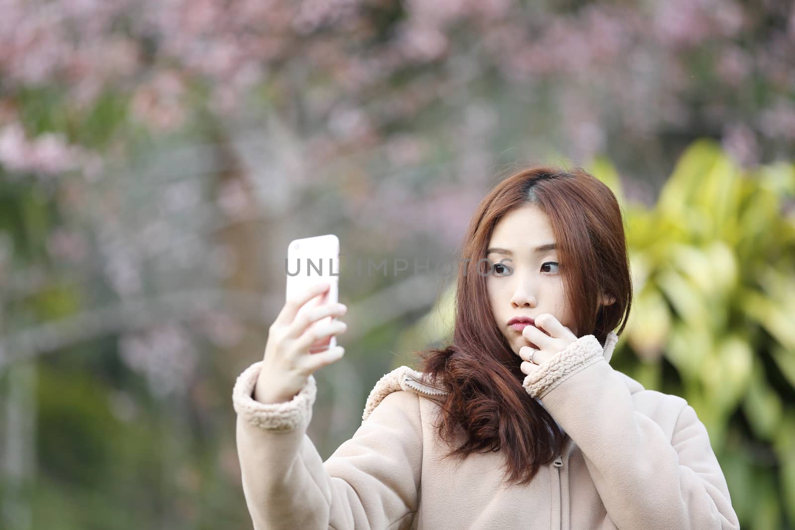 Asian woman selfie with cherry blossom sakura by piyato