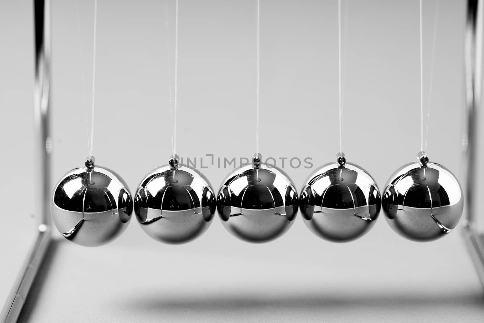 Newtons Cradle balancing balls, business concept in studio by Alicephoto